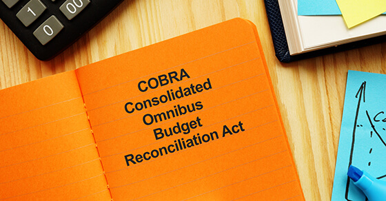 Orange book on top of a desk with the title Consolidated Omnibus Budget Reconciliation Act