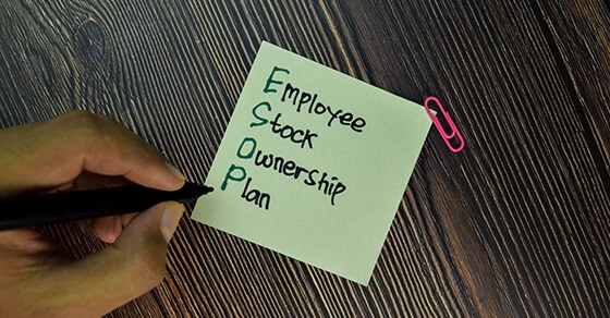 ESOP - Employee Stock Ownership Plan write on sticky note isolated on Wooden Table. Business concept