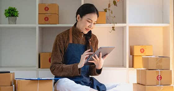 Beautiful business woman owner selling online using tablet to chat with customer