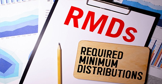 Clipboard with RMDs Required Minimum Distributions typed on it with a pencil laying across it
